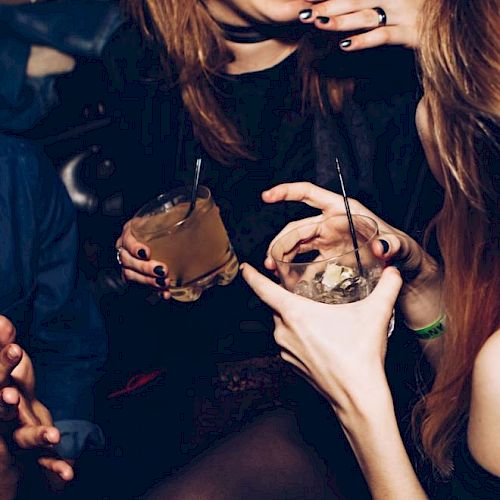 People enjoying a social gathering with drinks, having fun and conversing.