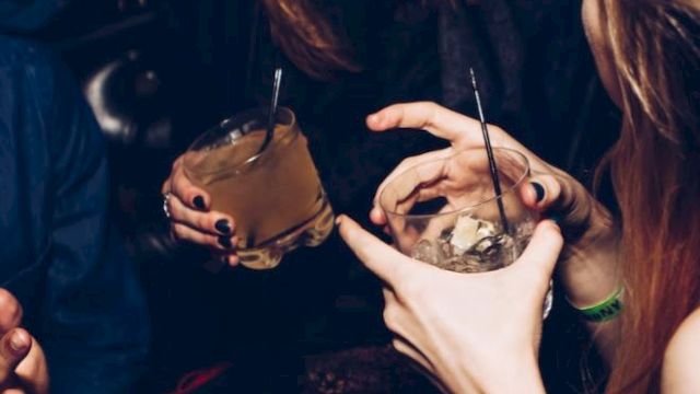People enjoying a social gathering with drinks, having fun and conversing.