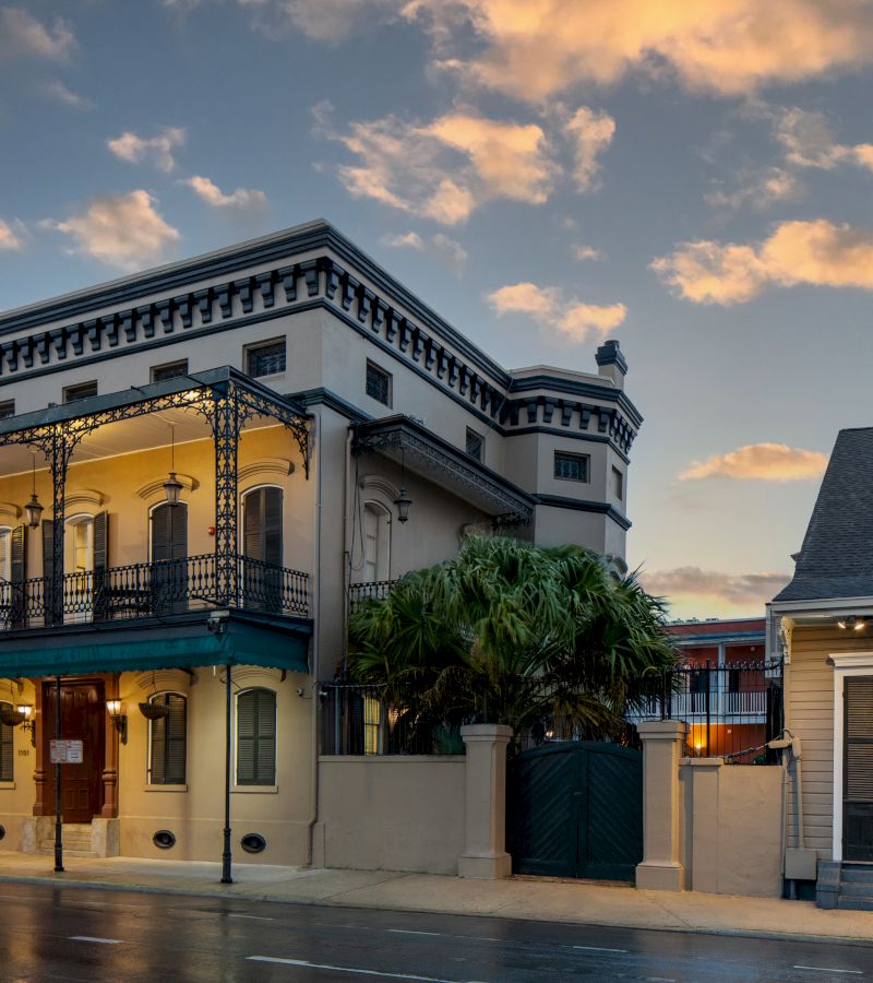 A wide exterior view of a building with a balcony and gate.