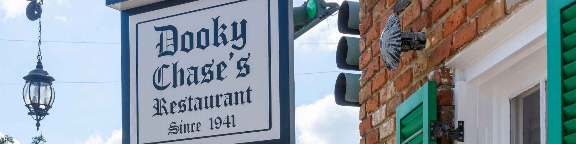 The image shows the exterior of Dooky Chase's Restaurant with a historical silhouette marker on the sidewalk.